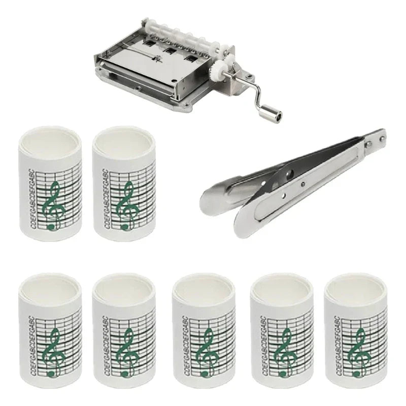 Set of eight white cylindrical paper tape rolls with green music notes and silver hand crank music box mechanism for 15note diy hand