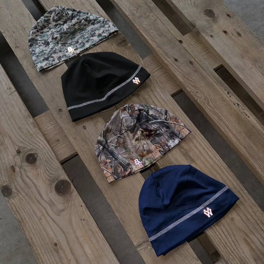 Four knit beanie hats in camouflage black and navy blue with embroidered logos for casual street style wear