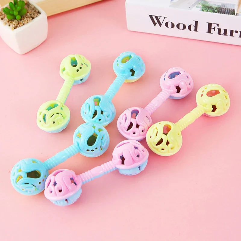 Three pastel-colored double-headed plastic baby rattles with perforated spherical ends and textured handles small toy rattle