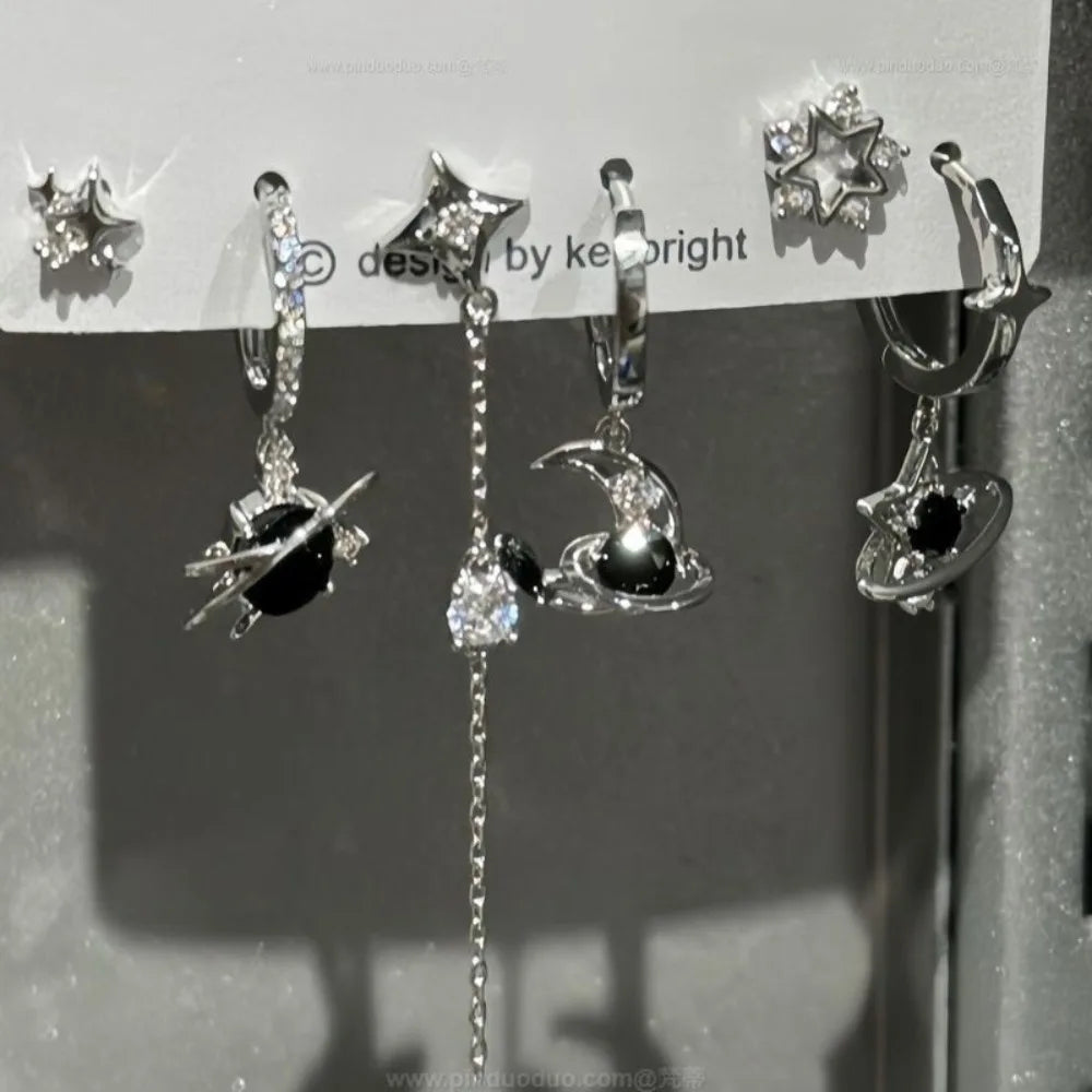 Silver space-themed hoop earrings with black gemstone planets and crystal accents for rock y2k jewelry fans