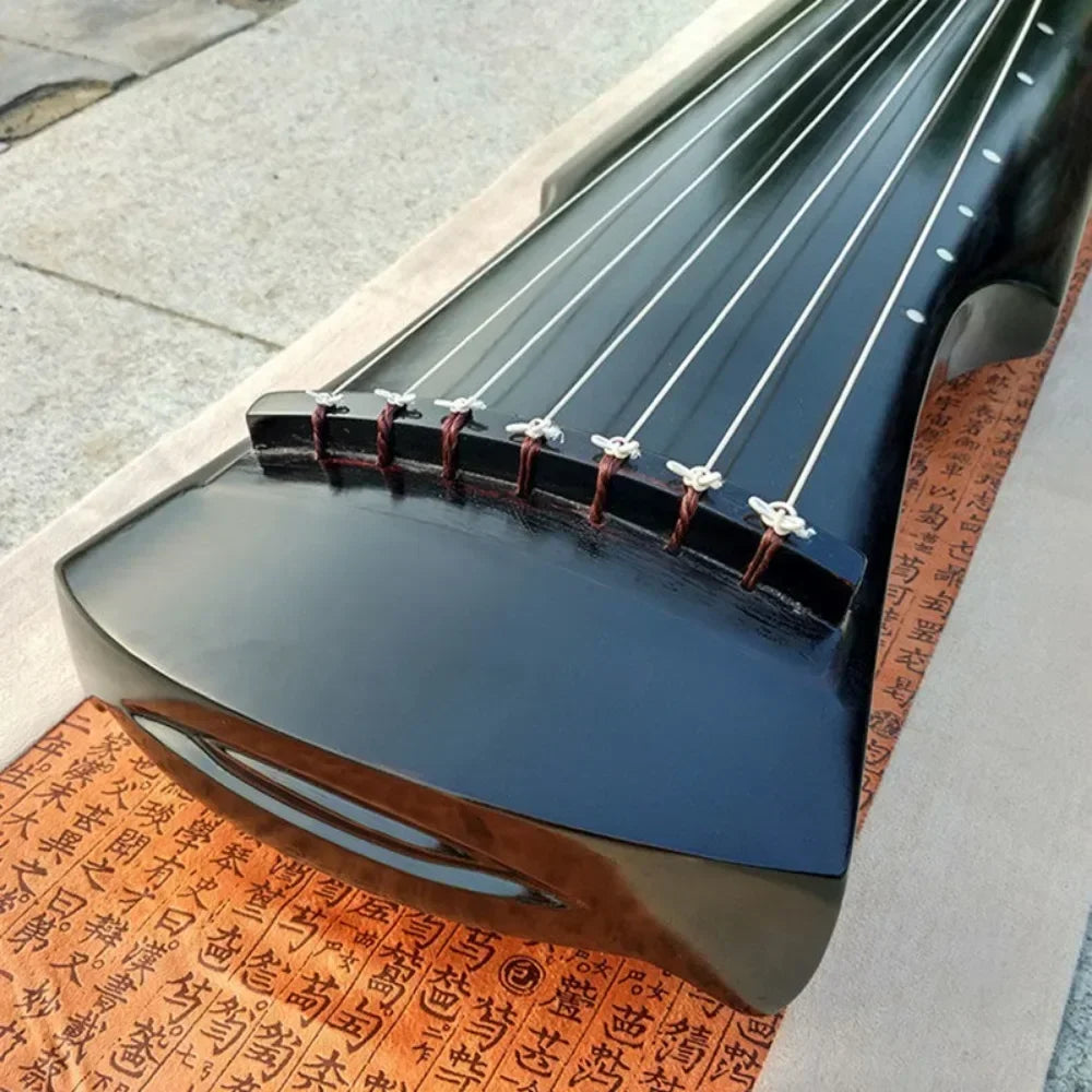 Black lacquered guqin zither handmade with seven strings and red and white tuning knots accessories chinese traditional
