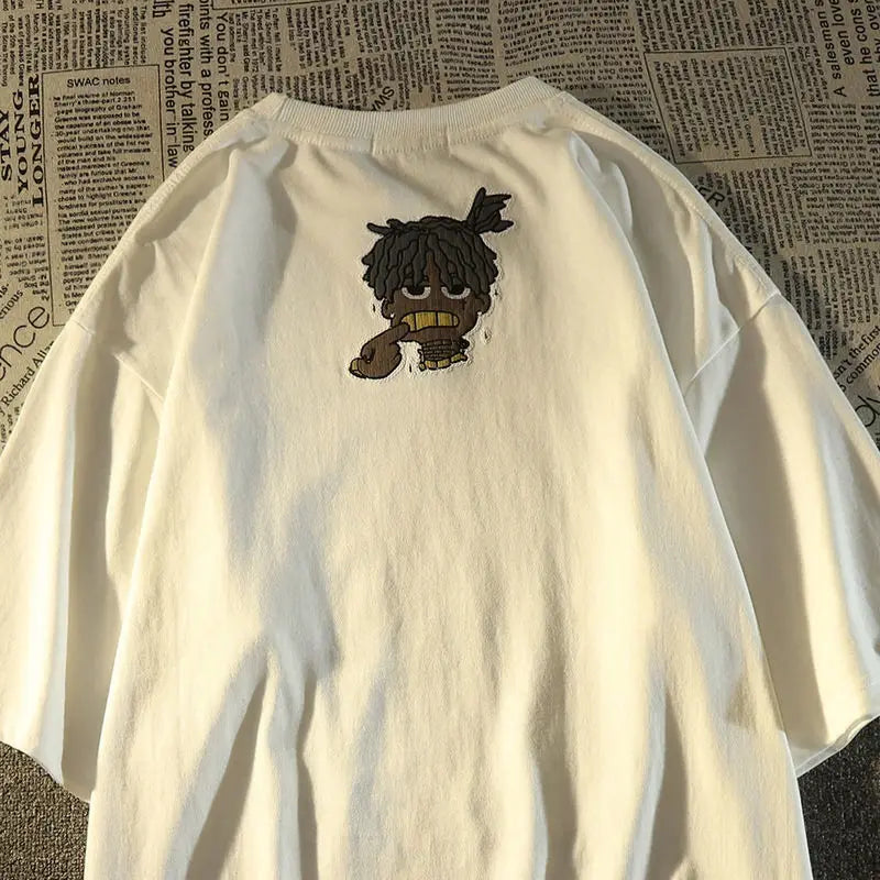 White oversized American hip hop fashion brand t-shirt showing back side with cartoon dreadlocks and gold teeth embroidery