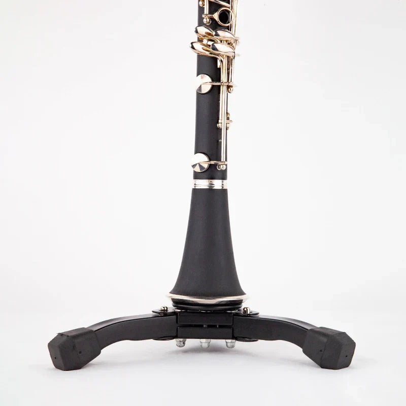 Black clarinet resting on a portable foldable universal metal clarinet instrument stand display rack tripod in black