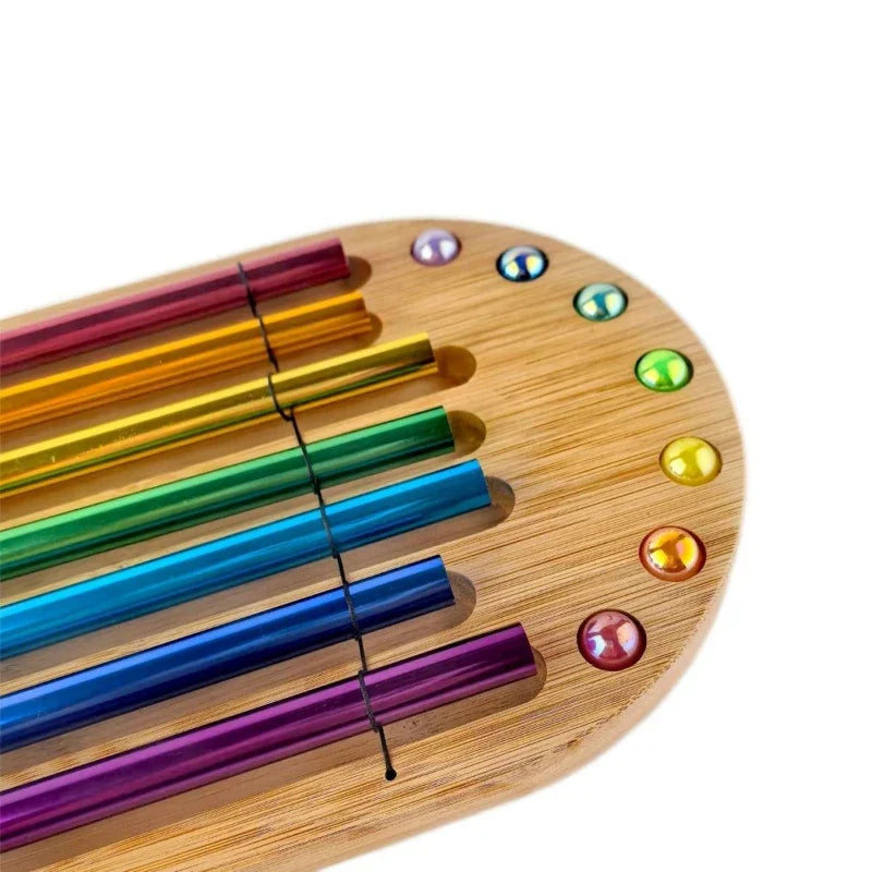 Rainbow-colored metallic straws and gemstones in a wooden holder for colorful sound bundle meditation spiritual healing
