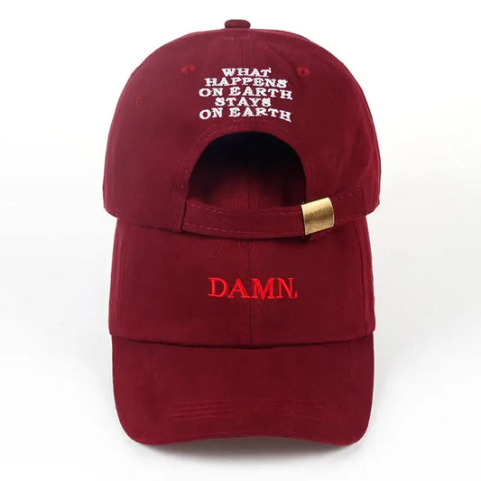 Back view of a maroon embroidered dad hat with what happens on earth stays on earth text and gold-tone strap adjustment