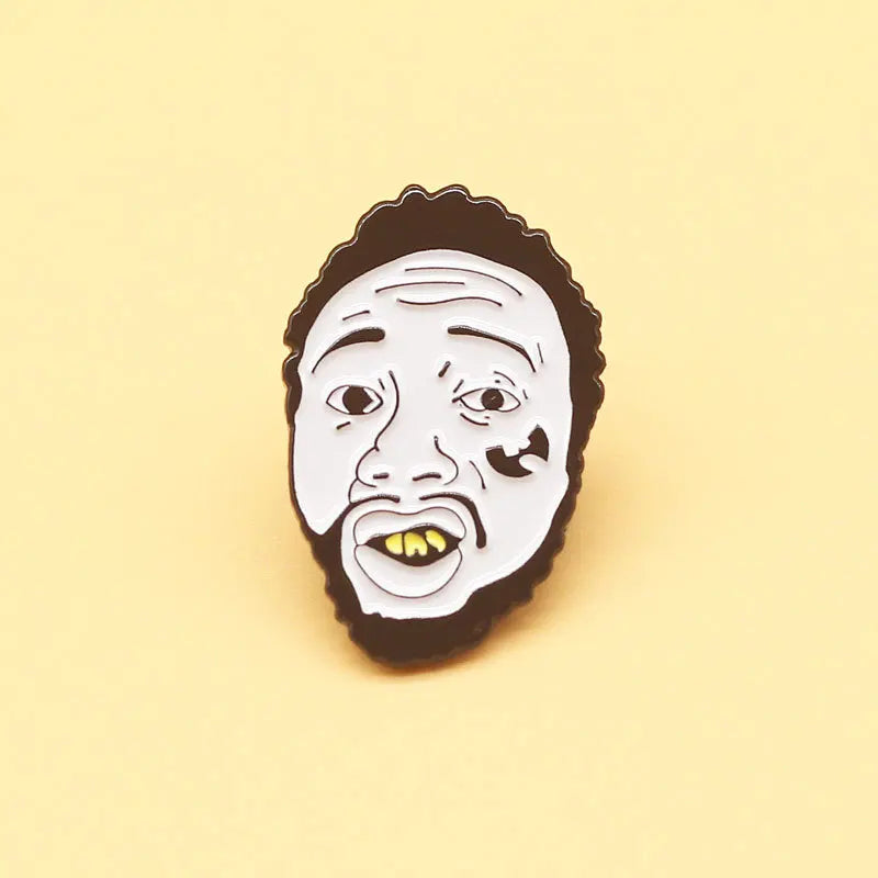 White enamel lapel pin with black outline and yellow teeth featuring a stylized face for rapping music collect badge jewelry
