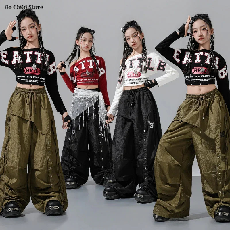 Four young women wearing matching hip hop cropped tops and olive green or black cargo pants kids street dance clothes