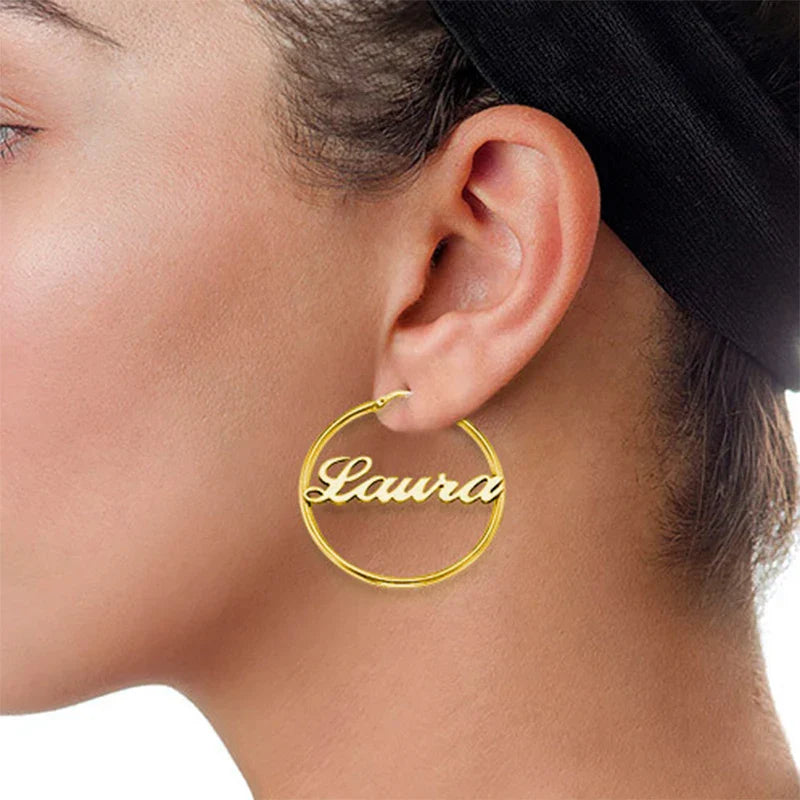 Gold-colored stainless steel round circle oorbellen with custom jewelry personalized name laura engraved in cursive script