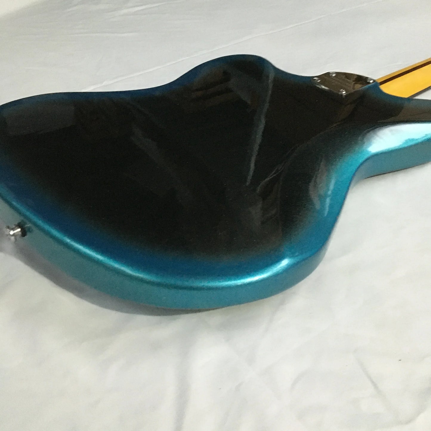 Glossy teal and black gradient jazzmast electric guitar with rosewood fingerboard and modern sleek body design