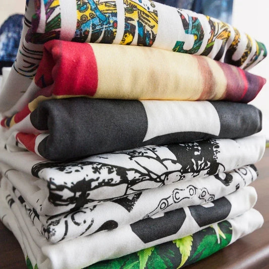 Stack of folded cotton men’s Mike Tyson retro pattern black hip-hop graphic tees in assorted colors and designs