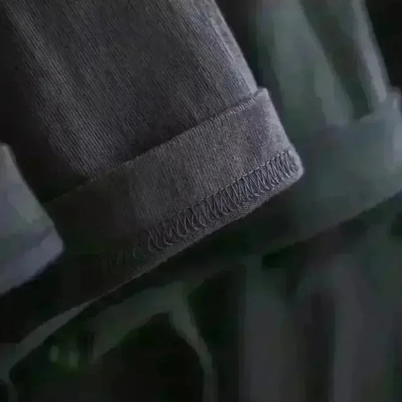 Dark gray denim pant leg with rolled cuff visible stitching alongside a stop talking nonsense rapper band t shirt