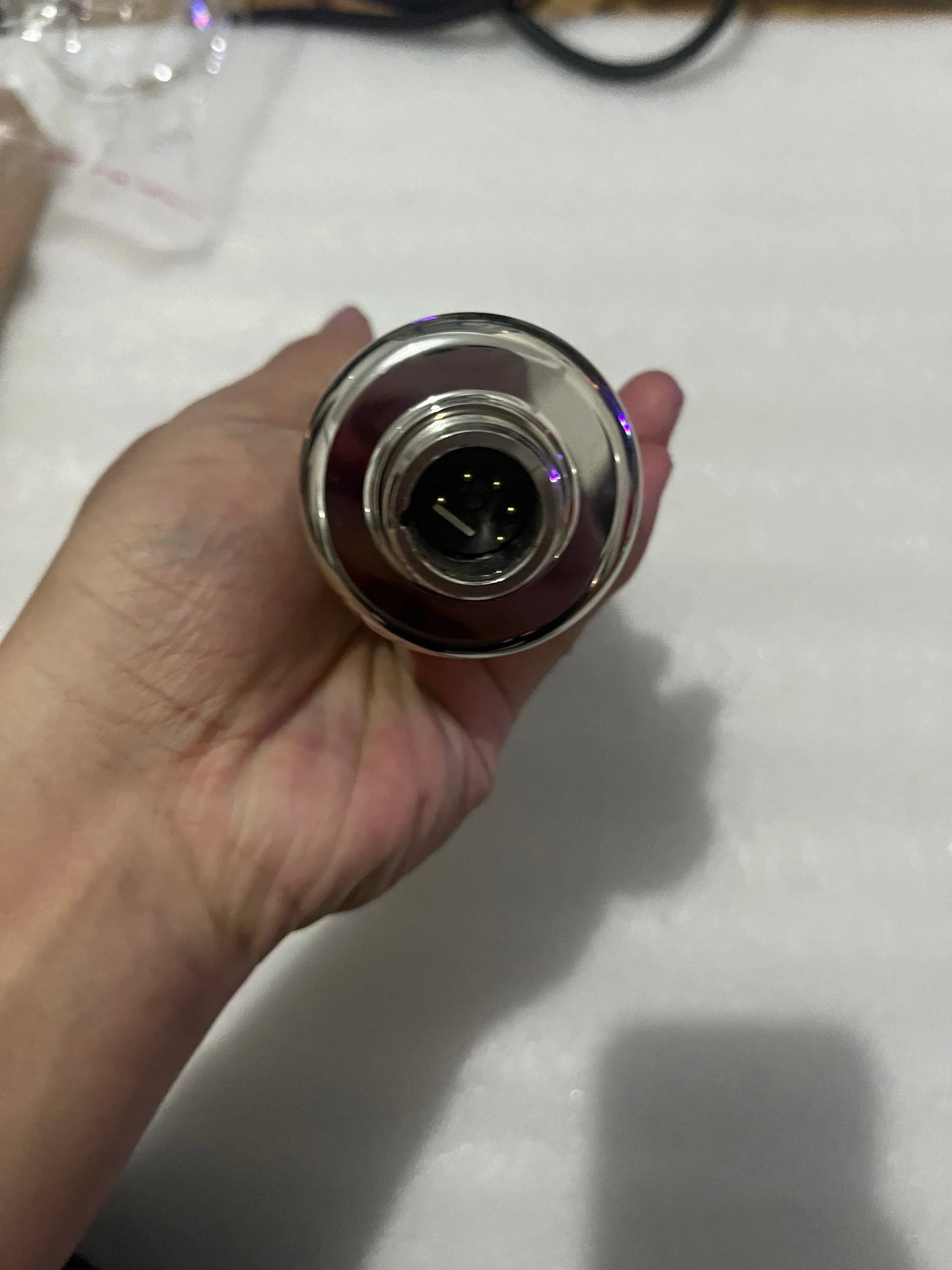 A sleek silver metallic cylindrical vape pen with black mouthpiece featured alongside a vacuum tube microphone for professional recording studios with cardioid pickup