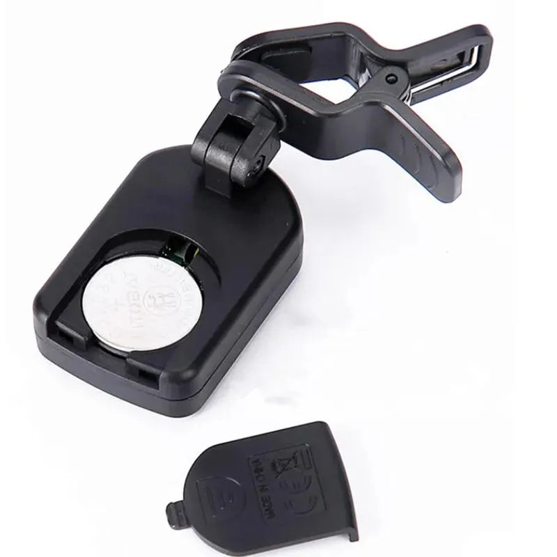 Black plastic clip-on lcd digital tuner with circular battery compartment and removable cover for string instruments