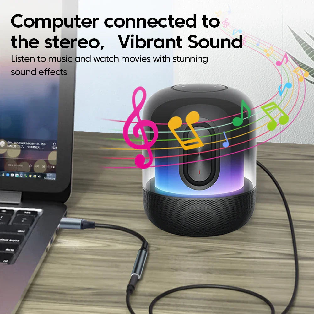 Black cylindrical speaker with translucent front glowing led lights connected to laptop via headset microphone usb audio jack adapter external stereo sound card