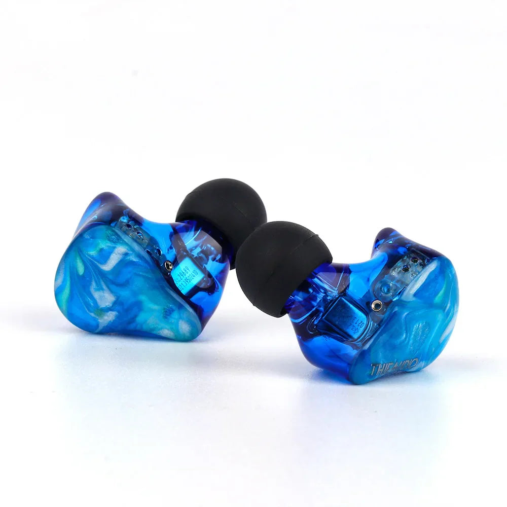 Blue translucent thieaudio legacy hybrid in-ear monitor with black silicone tips designed for audiophiles musicians