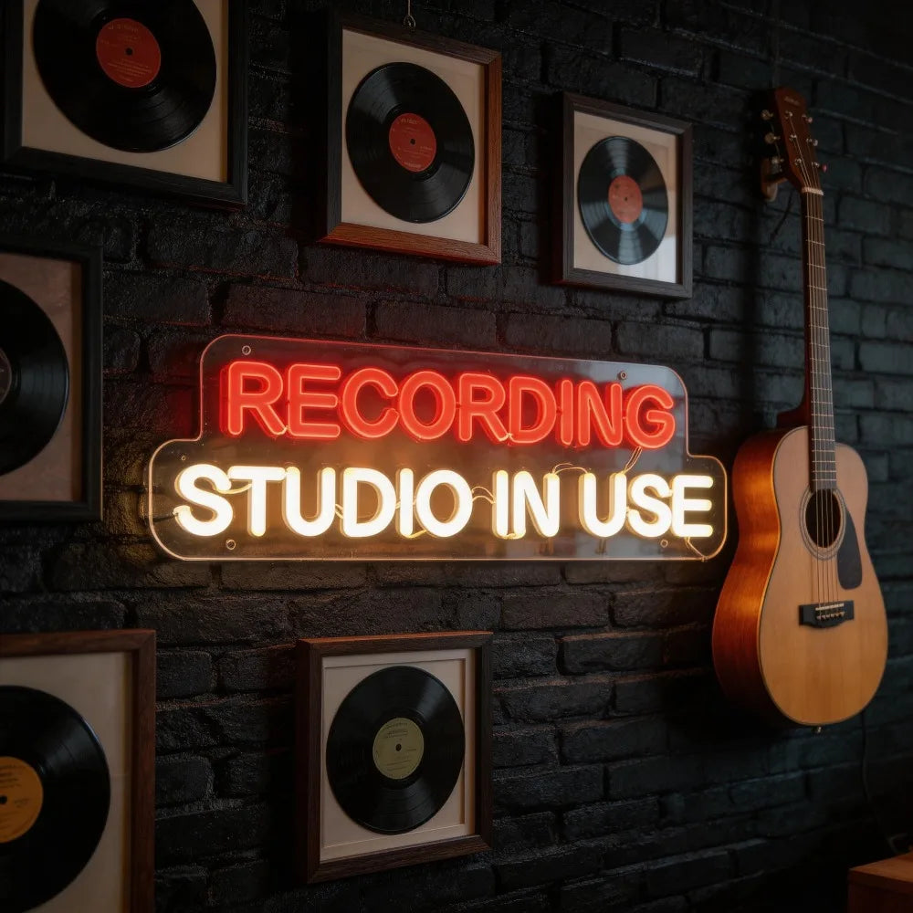 A glowing red and white recording studio neon sign with adjustable led letters on a dark brick wall for music entertainment room