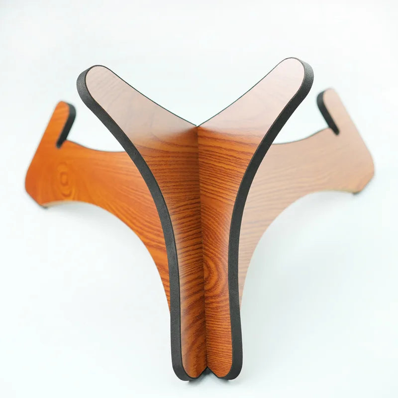 A sleek y-shaped solid wood drum stand with amber finish and black trim for portable handpan storage and tongue drums display