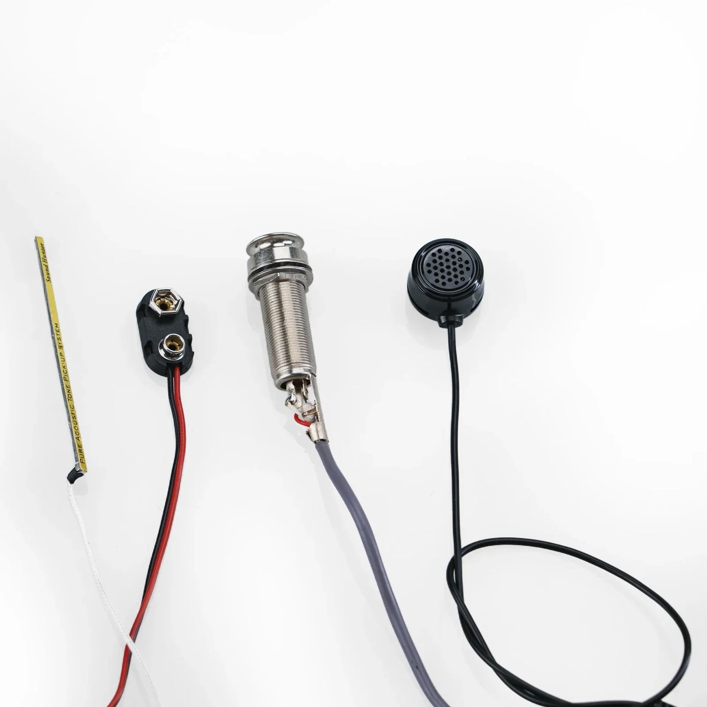 Silver-toned sound hunter acoustic hole pickup noise active piezo with threaded metal body and coiled wire connected to speaker cables