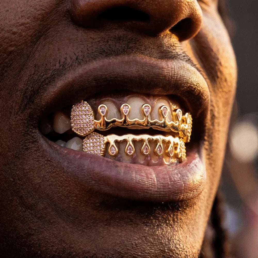 Gold-colored diamond-encrusted hiphop teeth grillz with teardrop design and sparkling rhinestone tooth caps for punk bling style