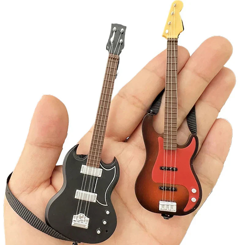 A hand holds two miniature guitar keychains in black and red gradient for dollhouse miniature furniture playset decor
