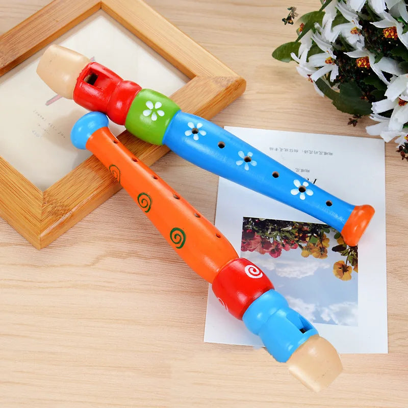 Two wooden colorful piccolo flutes in orange with green swirls and blue with white flowers for kids learning rhythm