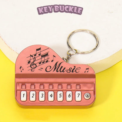Pink mini electronic piano keychain pendant with numbered keys and luminous music toy design for small gifts