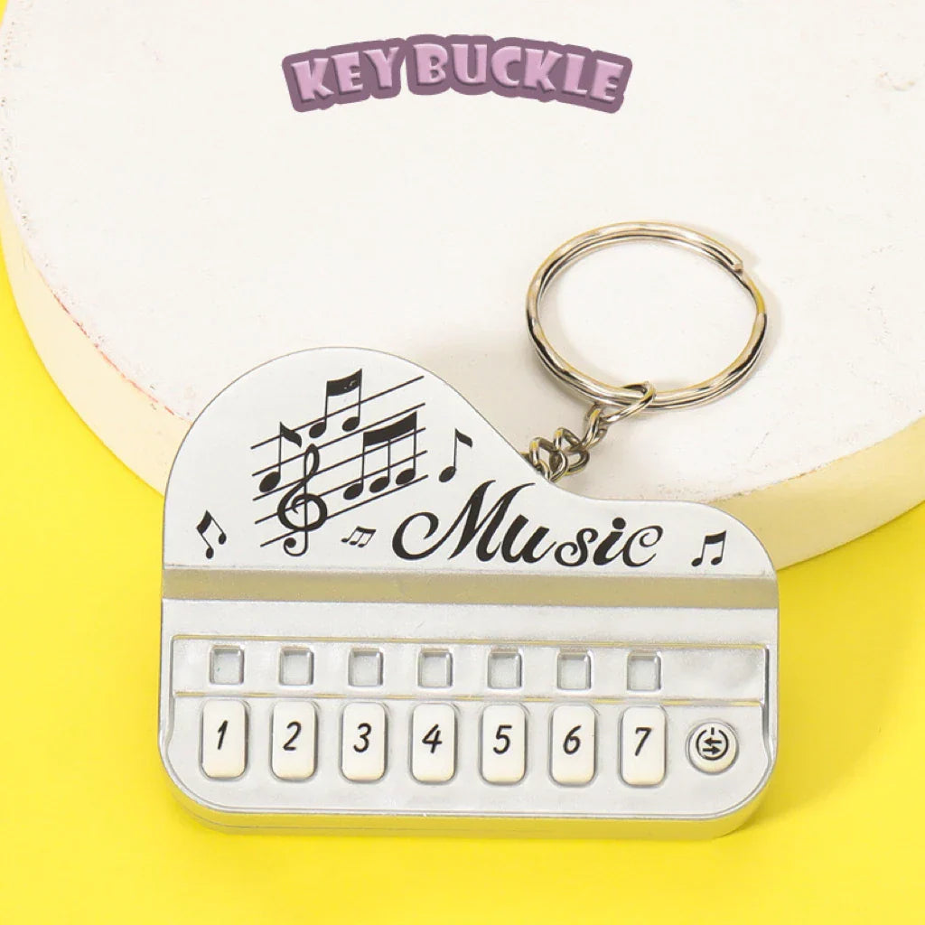 Silver mini electronic piano keychain pendant engraved with music notes and the word music luminous music toy