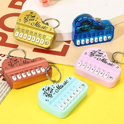Heart-shaped mini electronic piano keychain pendant with colorful body white buttons luminous music toy design
