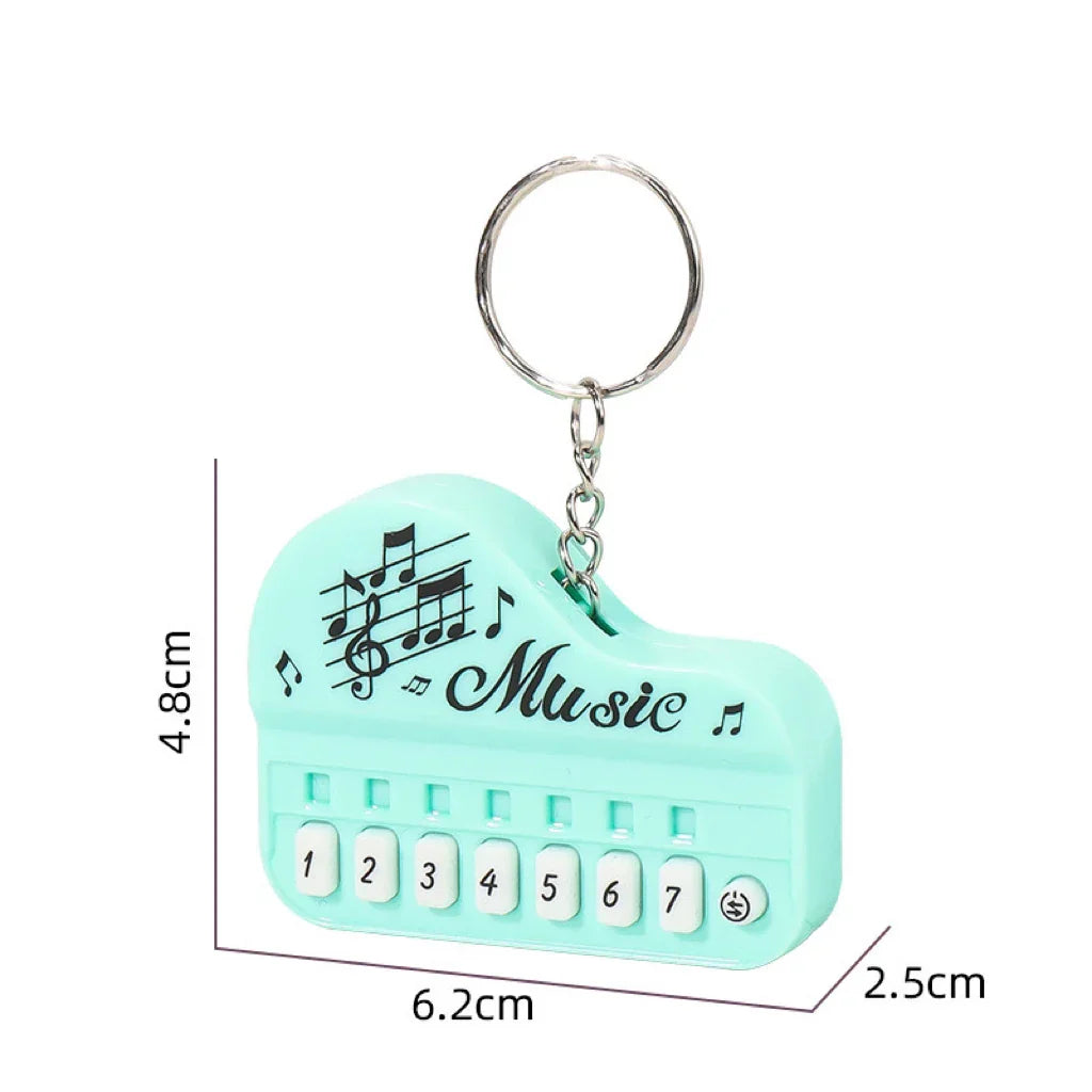Mint green plastic mini electronic piano keychain pendant with white numbered keys and luminous music toy decals