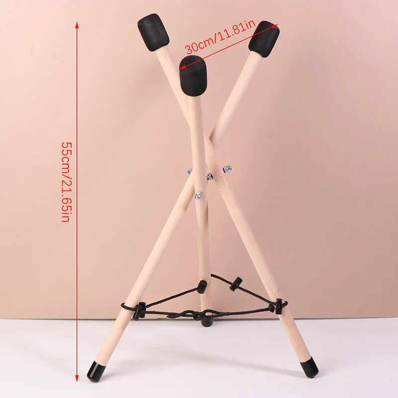 Light-colored solid wood triangle drum stand with adjustable height and black rubber caps for percussion instruments