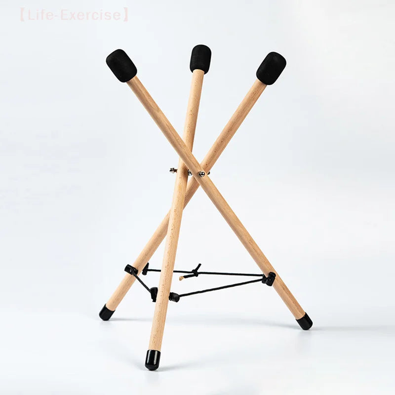 Light-colored solid wood triangle drum stand with black rubber tips and central crossbar for percussion instrument adjustable use