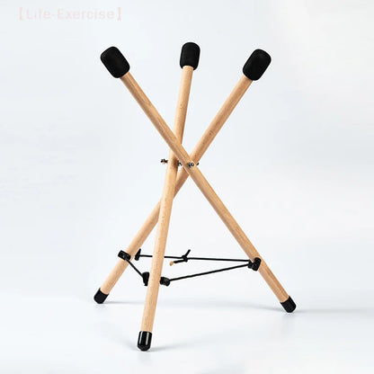 Light-colored solid wood triangle drum stand with black rubber tips and central crossbar for percussion instrument adjustable use