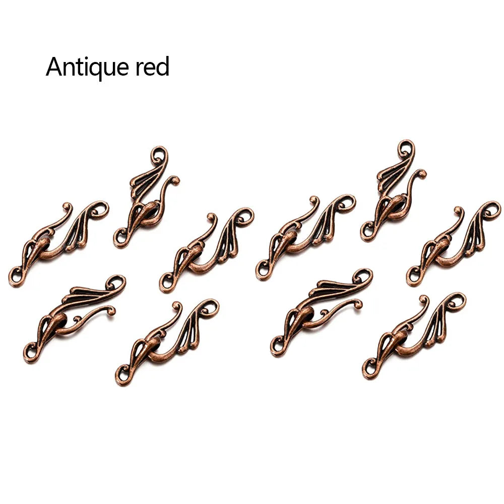 Antique red metal filigree connectors with ornate swirling designs for jewelry making and antique bronze silver musical note hook use