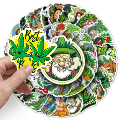 A hand holds a vibrant green 100pcs funny hemp waterproof suitcase luggage sticker with smoking cartoon graffiti
