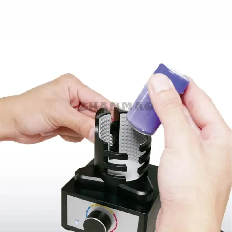 Purple cylindrical battery held above black and silver adjustable clamps on eddy current mixer for hobby model making