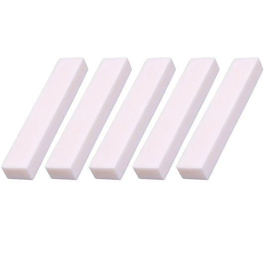 Five white rectangular guitar blank bone polishing pads for buffalo bone guitar nut professional use arranged in a row