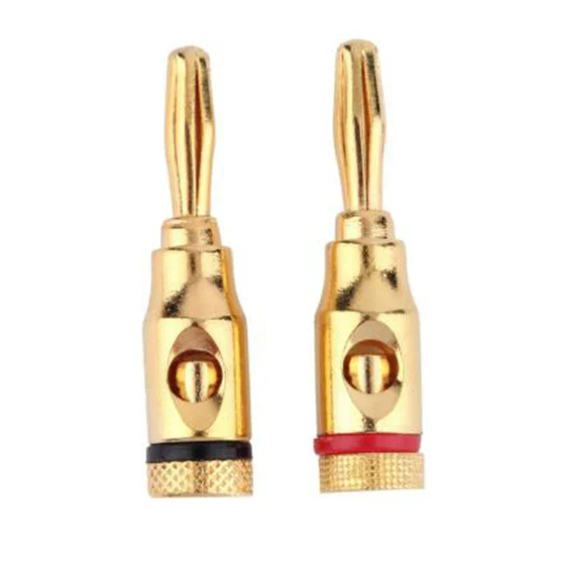 A pair of gold-colored 24k gold-plated banana plug audio speaker connectors with black and red bands at base