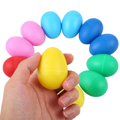 A hand holds a bright yellow plastic egg shaker among colorful kids toys plastic musical instruments percussion eggs