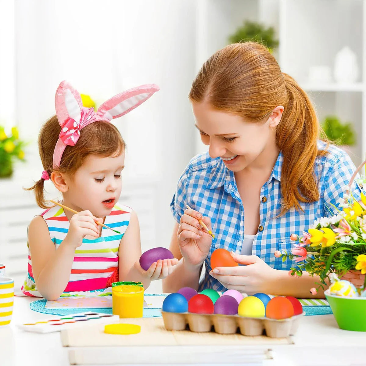 A child wearing pink bunny ears holds a purple plastic egg shaker percussion while painting it for party favors supplies