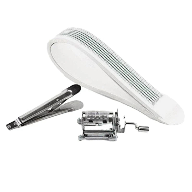 White measuring tape with black grid lines and silver tongs beside a small mechanical paper tape 15note diy hand crank music box movement