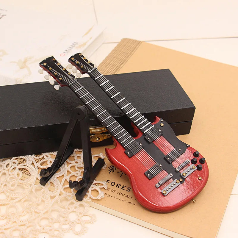 Red miniature wooden musical instruments mini electric guitar with black pickguard on support miniature model stand