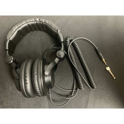 Black over-ear headphones with padded earcups and coiled cable featuring gold-plated connectors for podcast recording