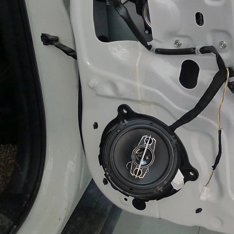 Black circular 350w universal car hifi coaxial speaker with white logo mounted in white car door panel