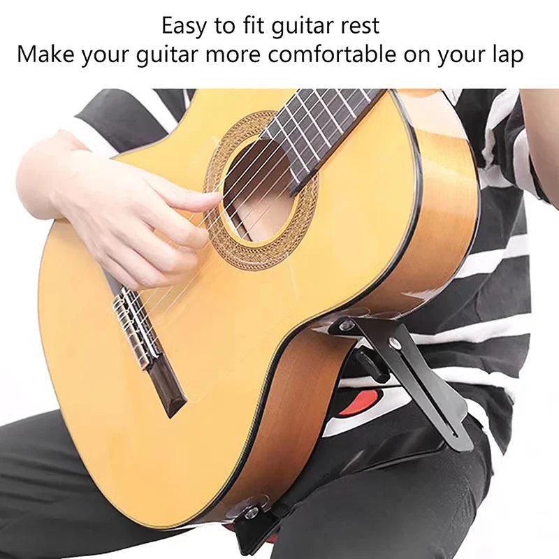 Black metal acoustic guitar footrest supporting a light wood acoustic guitar classical guitar backrest frame