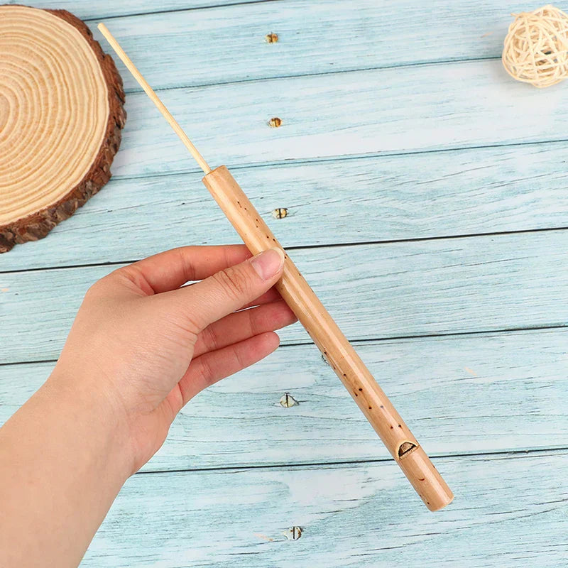 A light brown bamboo musical instrument bird whistle flute with small holes for mini music rhythm and kids holiday gifts