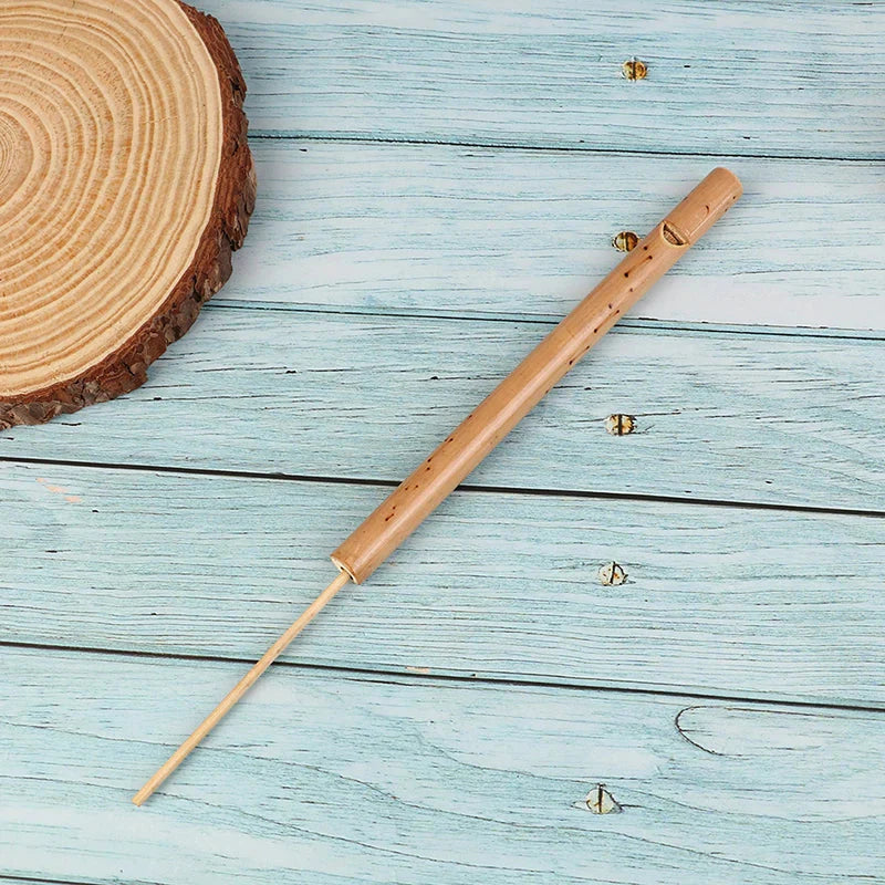 A light brown bamboo musical instrument mini music rhythm instrument bird whistle with slender cylindrical body and mouthpiece