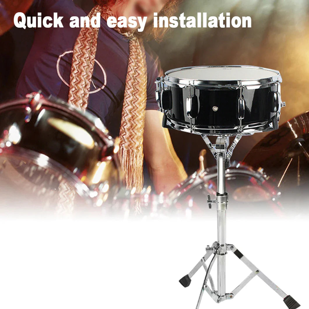 Black snare drum with chrome hardware mounted on an adjustable silver concert drum stand with drumstick holder