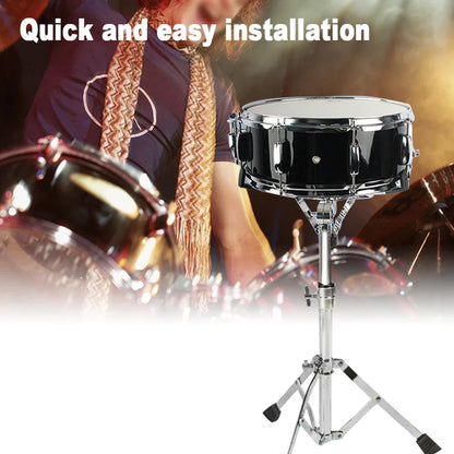 Black snare drum with chrome hardware mounted on an adjustable silver concert drum stand with drumstick holder