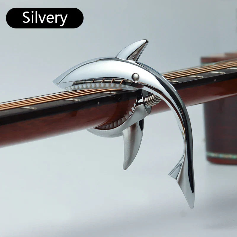 Silver metal shark capo with polished metallic finish and detailed teeth for electric guitar tone and clip bass bridge use