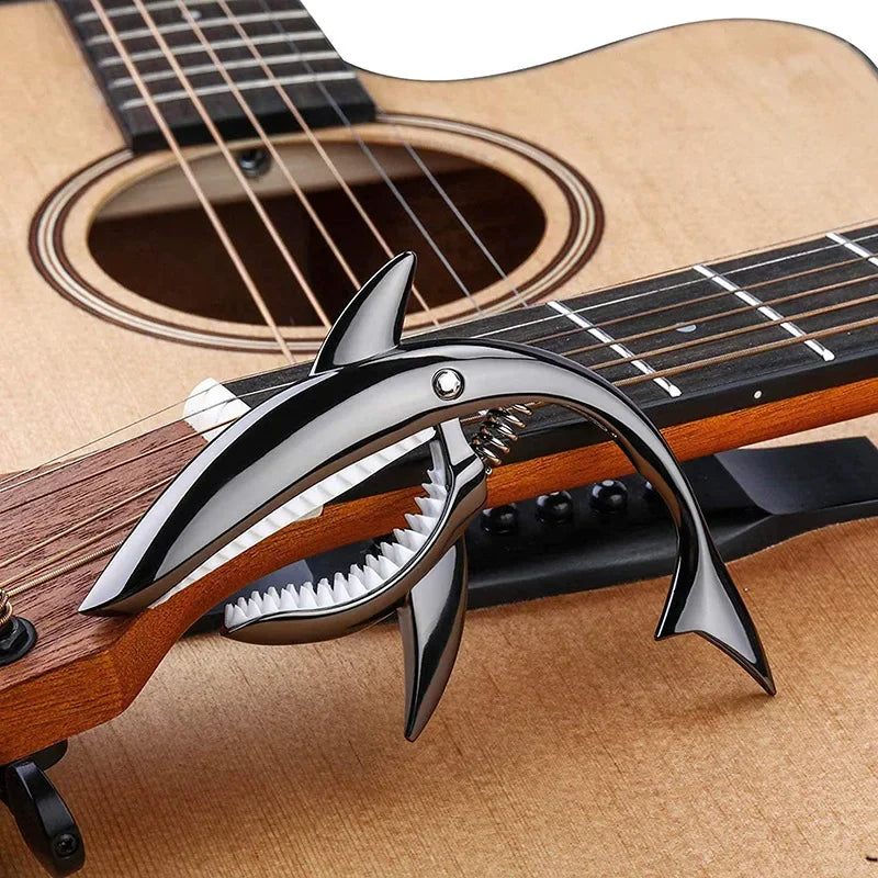 Shark-shaped metal shark capo with sharp teeth and sleek black zinc alloy finish for electric guitar tone and clip bass bridge use